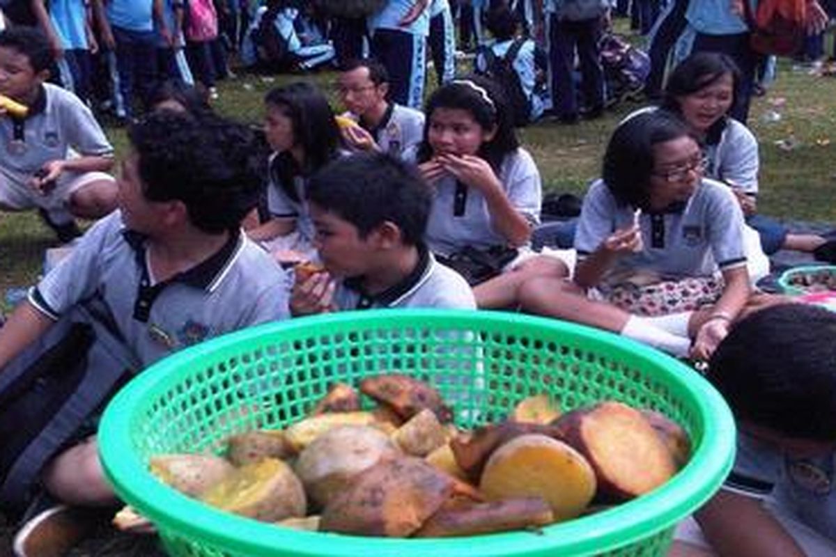 Sejumlah peserta terlihat sedanag makan ubi saat berlangsung acara kampanye sehari tanpa nasi di Lapangan Kostrad, Depok, Minggu (22/4/2012). Dengan peserta 24.520 orang, kampanye ini dicatat di Museum Rekor Dunia Indonersia (MURI).