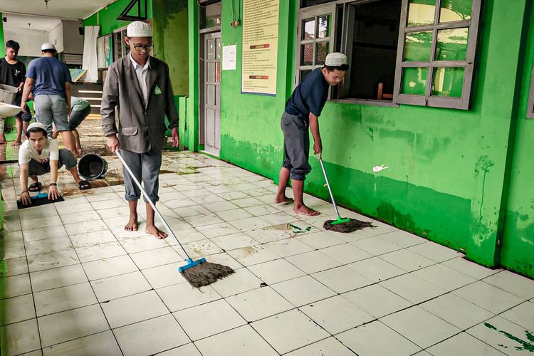 Siswa membersihkan sekolah yang sempat terendam banjir, Selasa (9/5/2023).