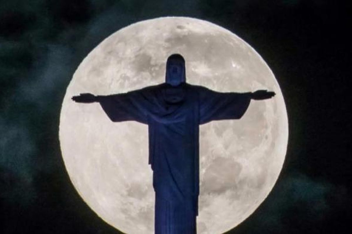 Bulan purnama dengan latar depan patung Kristus Penebus di atas bukit Corcovado di Rio de Janeiro, Brasil, 25 Mei 2013. Paus Francis akan mengunjungi Rio de Janeiro selama acara World Youth Day pada 23-28 Juli.