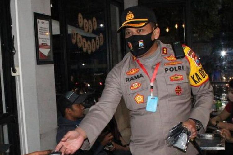 Kapolres Bangkalan, AKBP Rama Samtama Putra saat membagikan masker gratis kepada pengunjung cafe di Jl. KH. Moh Cholil Bangkalan, Sabtu (4/7/2020) malam. Pembagian masker diikuti juga dengan penyemprotan disinfektan di sejumlah jalan protokol di Kabupaten Bangkalan.