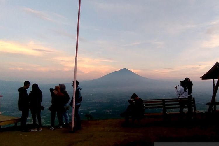 Sejumlah pengunjung menikmati pemandangan alam di Puncak Intan Dewata atau Gunung Putri, Kecamatan Tarogong Kaler, Kabupaten Garut, Jawa Barat. 