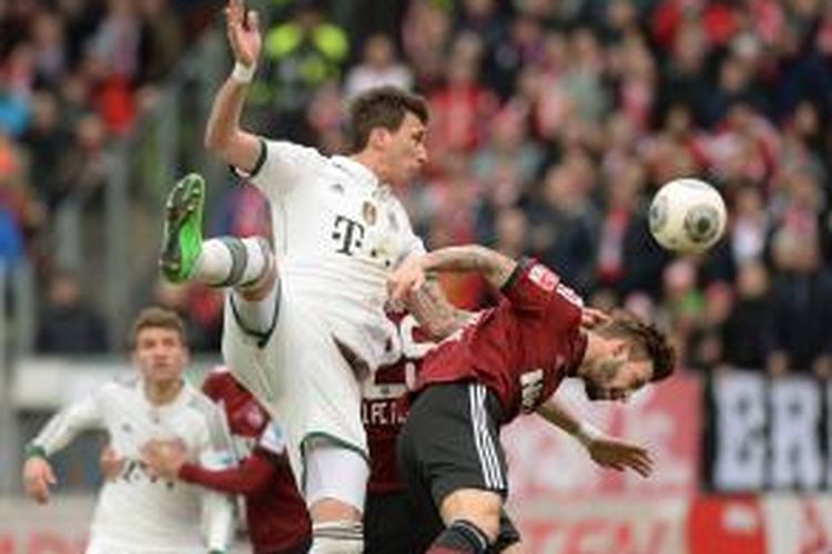 Penyerang Bayern Muenchen, Mario Mandzukic (kedua dari kanan) berebut bola dengan bek Nurnberg, Marcin Plattenhardt, pada pertandingan Bundesliga, di Nurnberg, Sabtu (8/2/2014).
