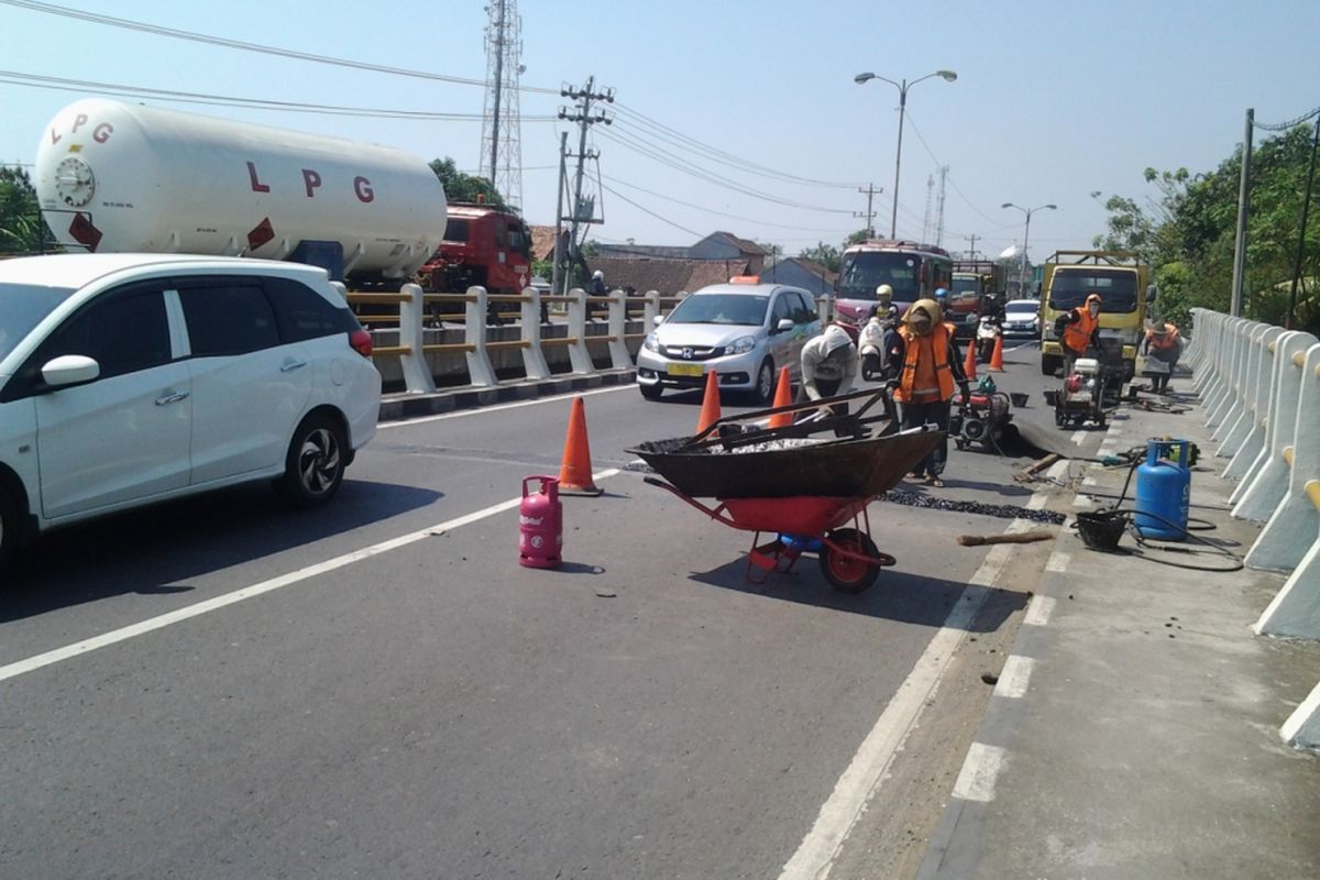 Petugas dari Bina Marga Kendal, saat memperbaiki sambungan jalan jembatan Brangsong Kendal. KOMPAS.Com /Slamet Priyatin 