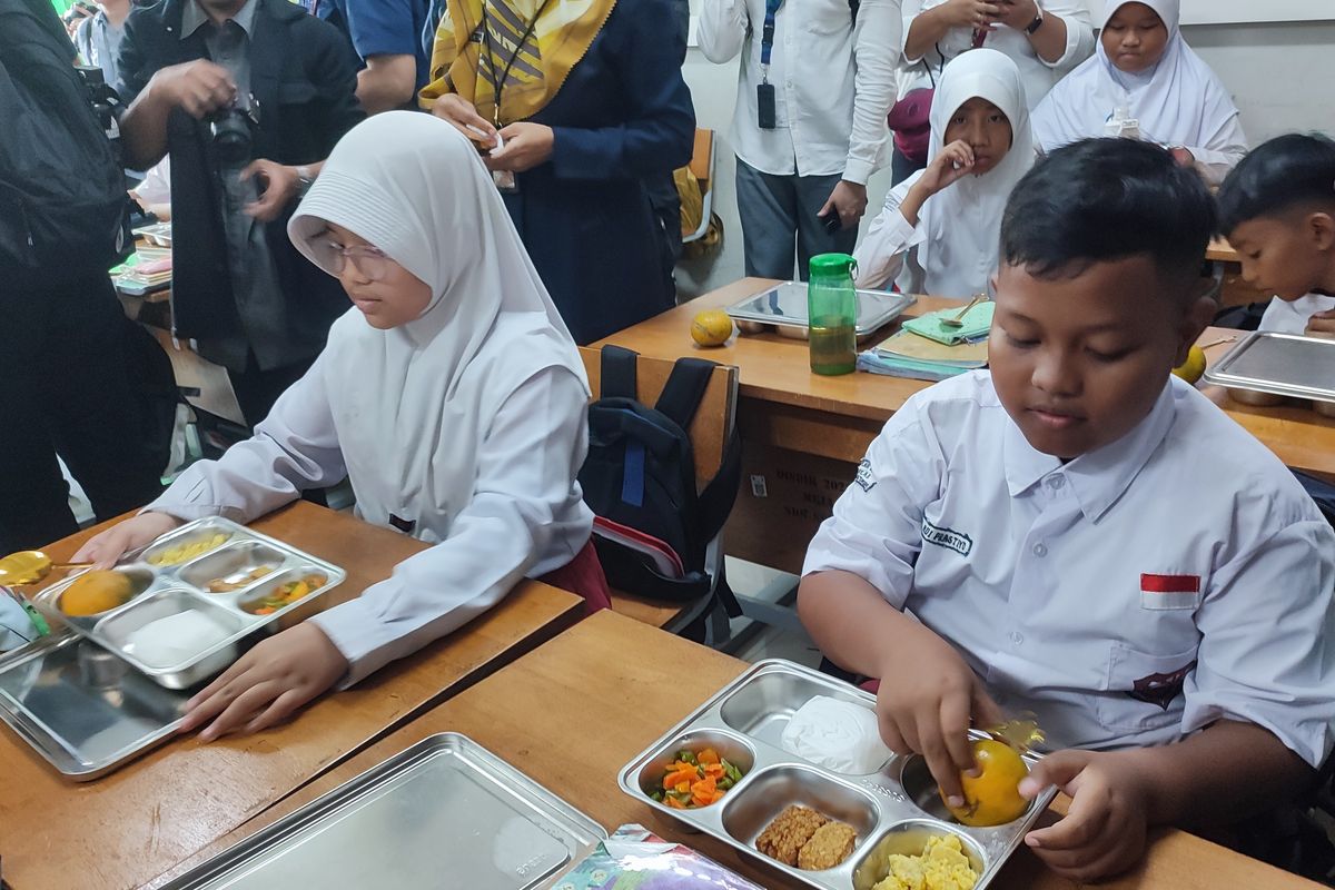 Siswa SD Susukan 01 ketika membuka makan bergizi gratis di SDN 01 Susukan, Ciracas, Jakarta Timur. 