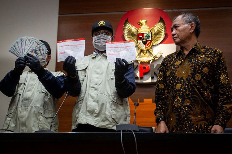 Ketua Komisi Pemberantasan Korupsi (KPK) Agus Rahardjo (kanan) menyaksikan petugas KPK menunjukkan barang bukti Operasi Tangkap Tangan (OTT) pengurusan izin impor bawang putih di Gedung KPK, Jakarta, Kamis (8/8/2019). KPK menetapkan enam orang tersangka dalam kasus dugaan pengurusan kuota dan izin impor bawang putih tahun 2019 di antaranya I Nyoman Dhamantra dan pemberi suap pemilik PT Cahaya Sakti Agro CFU alias Afung dengan barang bukti uang 50 ribu dolar AS serta bukti transfer sebesar Rp 2,1 miliar.