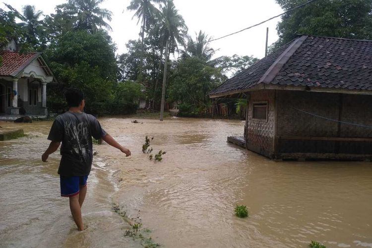 Seorang warga melintasi rumah yang terendam dalam peristiwa banjir bandang di Kabupaten Cianjur, Jawa Barat, Sabtu (3/10/2020)