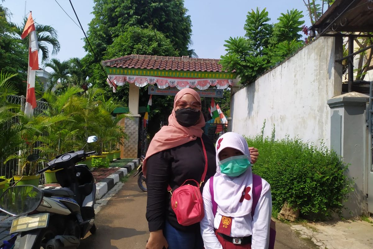 Siswi kelas 4 SDN Lebak Bulus 04 Pagi, Aira Maharani, bersama sang ibu di hari pertama PTM, Senin (30/8/2021). 