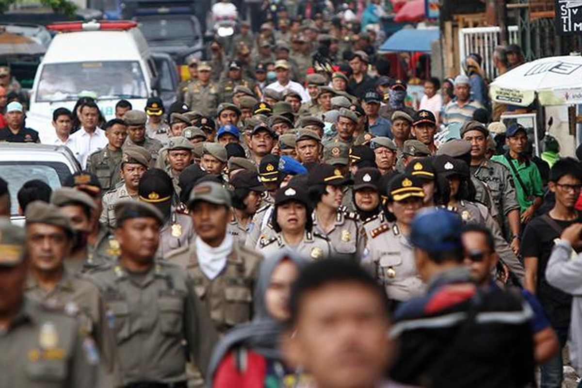 Ratusan Satpol PP dan Polisi dikerahkan untuk melakukan penggusuran di permukiman yang terkena proyek normalisasi Sungai Ciliwung, di Bukit Duri, Jakarta, Rabu (28/9/2016). Dalam periode Agustus hingga September 2016 ini tercatat sudah 313 keluarga pindah ke Rumah Susun (Rusun) Rawa Bebek di Jakarta Timur. Ditambah dengan 97 keluarga yang sudah lebih dulu direlokasi Januari kemarin, total ada 410 keluarga yang telah pindah.