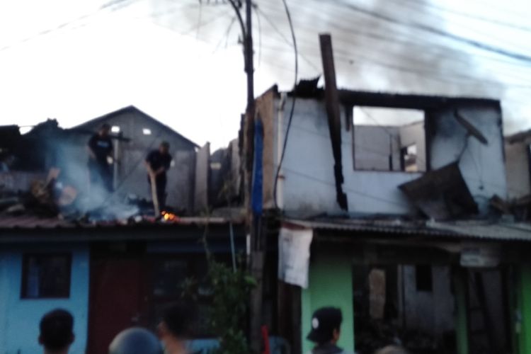 warga padamkan api dari puing puing yang ada di atap rumah saat peristiwa kebakaran di kawasan Kebayoran Lama, Jakarta Selatan, Senin (27/1/2020)
