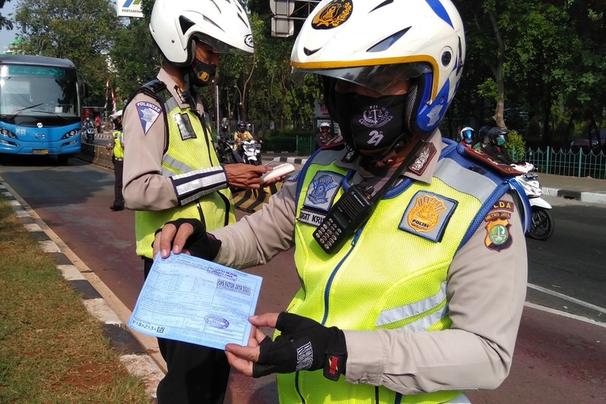 Panit Urai Satwil Lantas Polres Metro Jakarta Timur, Iptu Sigit Kris menunjukkan kertas biru yang dibuang anggota ASN saat ditilang, Kamis (23/7/2020)