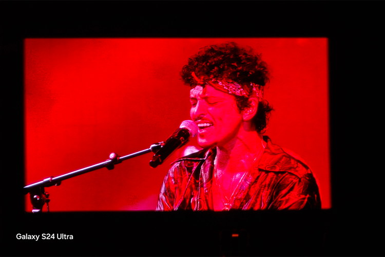 Wajah Bruno Mars yang sedang bernyanyi lagu Grenade sambil bermain piano. Foto diambil dari panel LCD di konser menggunakan Samsung S24 Ultra