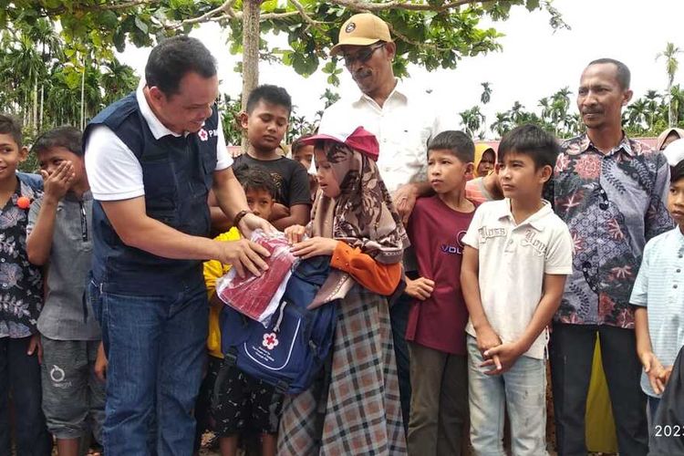 Ketua PMI Aceh Utara, Tantawi, menyerahkan bantuan pakaian sekolah untuk anak korban banjir di Desa Buket Linteung, Kecamatan Langkahan, Aceh Utara, Kamis (26/1/2023).