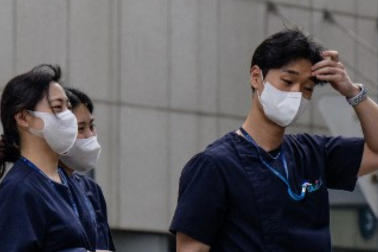 Pekerja medis berjalan di luar rumah sakit di Seoul pada 19 Maret 2024. Korea Selatan telah menangguhkan izin medis dua dokter, kata Asosiasi Medis Korea pada 19 Maret, sebagai tindakan positif pertama atas pemogokan selama sebulan yang menyebabkan kekacauan layanan kesehatan.