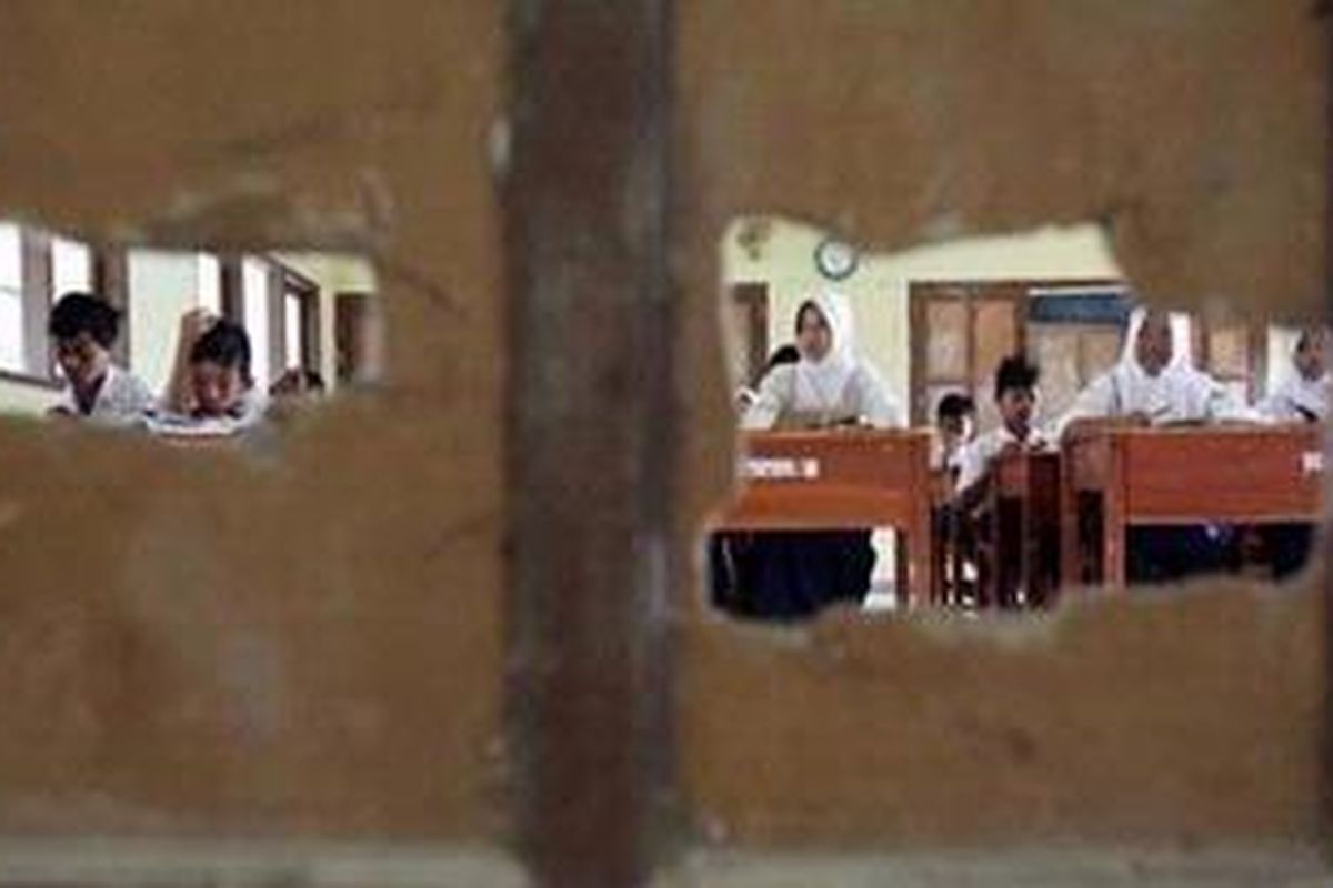 Dinding pembatas kelas Sekolah Menengah Pertama Sukasari 1, Kecamatan Sukasari, Kabupaten Purwakarta, Jawa Barat, Rabu (30/3), berlubang. Lantai sekolah di beberapa ruang di gedung sekolah itu pun rusak parah.