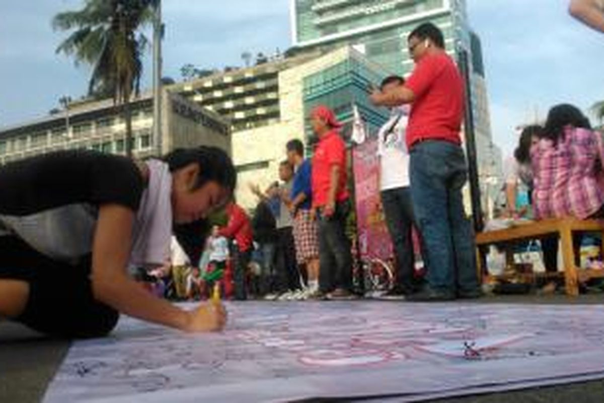 Salah satu warga Jakarta, membubuhkan tandatangan dukungan terhadap Ahok terkait e-budgeting di bunderan HI, Minggu (29/3/2015).