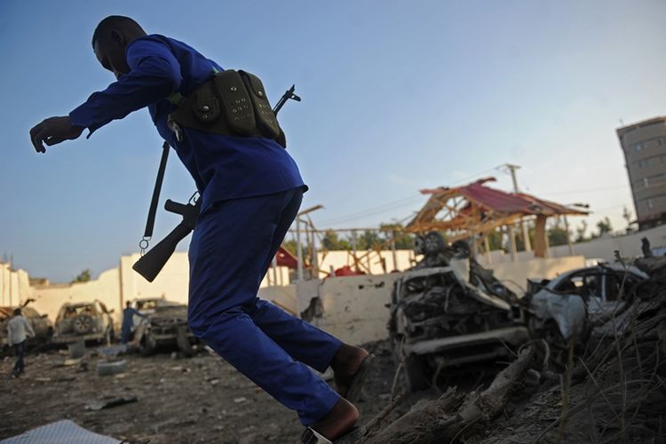 Petugas keamanan Somalia memeriksa lokasi ledakan bom mobil yang menghancurkan sebuah hotel di Mogadishu, Jumat (23/2/2018).
