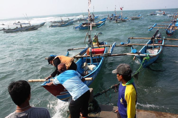 Aktivitas nelayan sebagai masyarakat pesisir di dermaga Pantai Jayanti, Cianjur, Jawa Barat. 