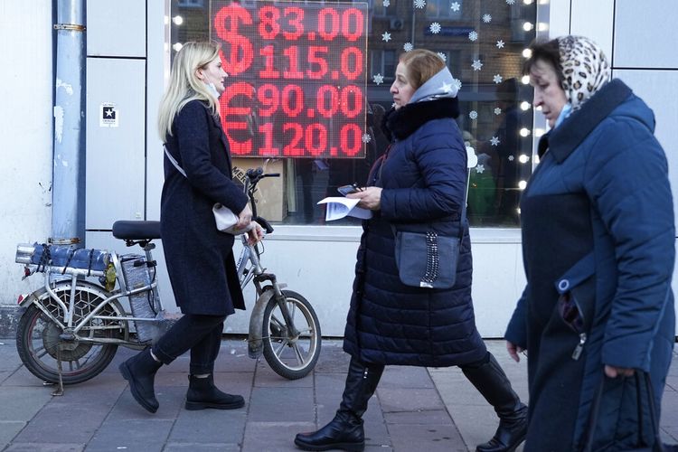 Orang-orang berjalan melewati layar kantor penukaran mata uang yang menampilkan nilai tukar Dolar AS dan Euro ke Rubel Rusia di pusat kota Moskow, Rusia, 28 Februari 2022.