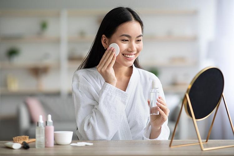 Ilustrasi membersihkan wajah dengan cleanser wajah.