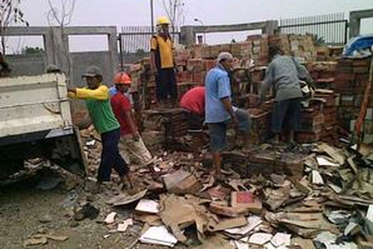 Pekerja membereskan ubin pasca dirusak massa