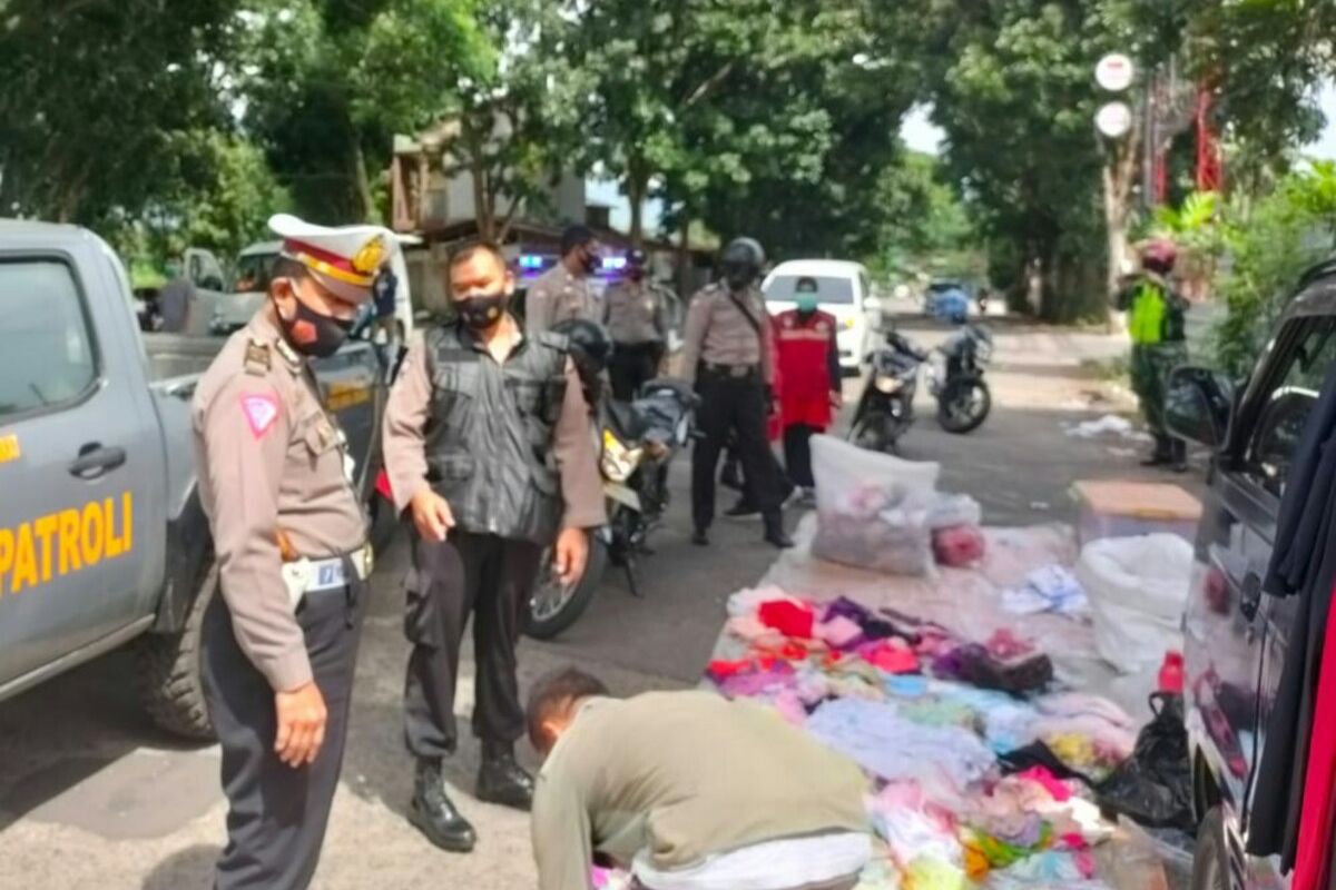 Sejumlah anggota Polri membubarkan aktivitas jualan puluhan pedagang di kawasan Car Free Day Bojong, Kabupaten Cianjur, Jawa Barat, Minggu (17/1/2021).