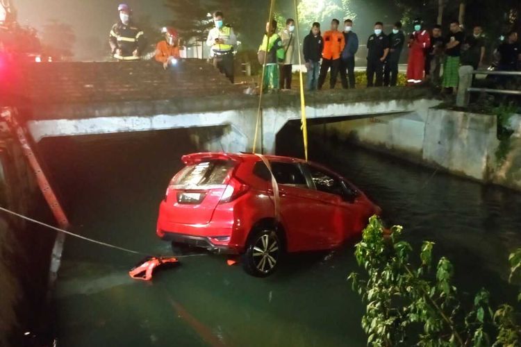 Mobil Honda Jazz Merah Yang dikemudikan Oleh Tiga Pemuda Sidoarjo Saat Dievakuasi Petugas di Sungai Prapen, Jumat (1/4/2022).