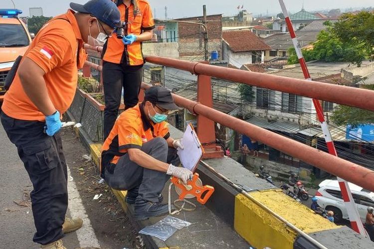 Petugas Inafis Polrestasbes Bandung saat melakukan proses evakuasi terhadap jasad pria yang gantung diri di jalan layang (flyover) Cimindi, Kota Bandung, Jumat (28/6/2024). 