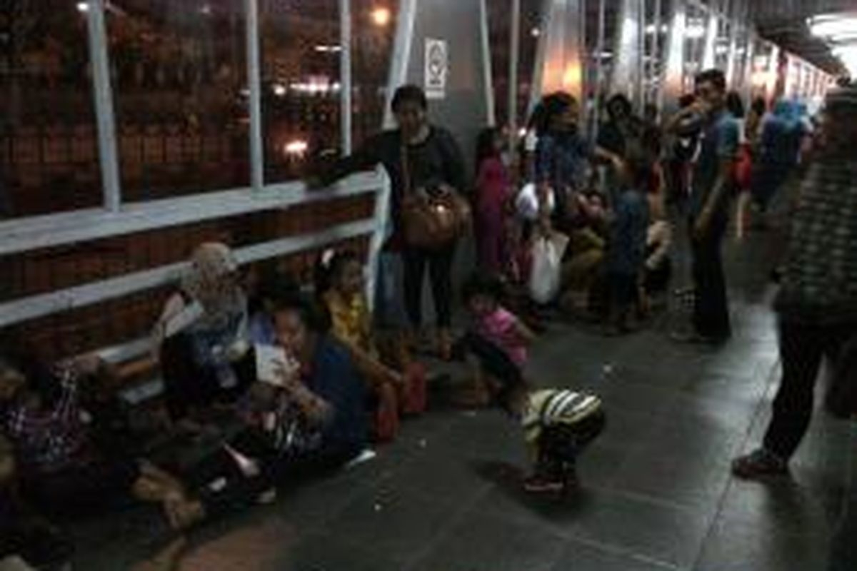 Masyarakat memenuhi Stasiun Pasar Minggu, Jakarta Selatan. Mereka banyak yang duduk di lantai peron dan di depan loket tiket. 