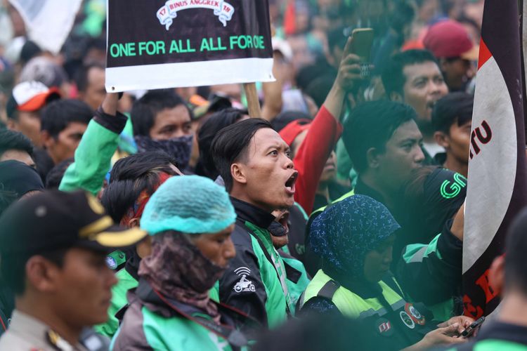 Sejumlah massa ojek online berunjuk rasa saat demo di depan Gedung DPR/MPR RI untuk berunjuk rasa menyampaikan aspirasinya, Senin (23/4/2018). Dalam demo ini para  pengemudi ojek online menuntut kenaikan tarif, Pengakuan legal, dan perlindungan hukum dan keadilan bagi ojek online.