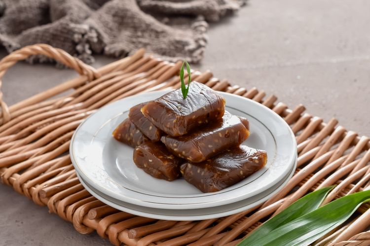 Gambar sebuah potongan dodol ketan yang menampilkan tekstur kenyal dan warna kecokelatan, menghadirkan kelezatan klasik yang telah dicintai oleh generasi-generasi