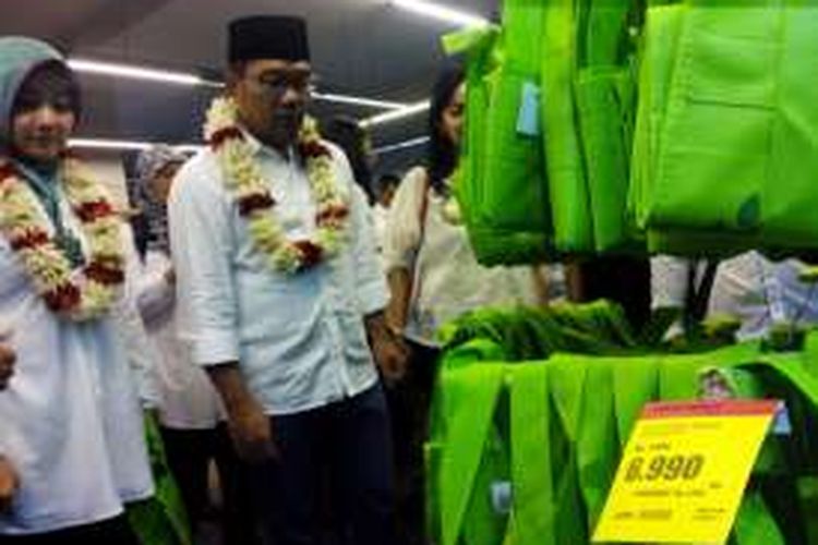 Wali Kota Bandung Ridwan Kamil bersama istrinya Atalia Praratya saat melihat kantong belanja pribadi yang mulai dijual sebagai cara menyukseskan program pengurangan kantong plastik di Superindo Jalan Ir. Djuanda (Dago), Minggu (21/2/2016).