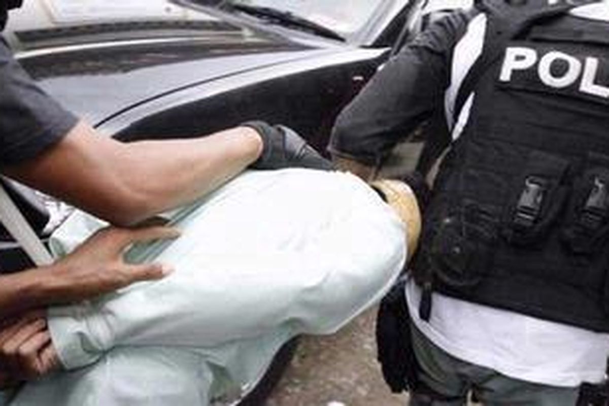 Petugas Densus 88 membawa seorang tersangka teroris dalam penggrebegan di Dusun Krapyak Sunggingan, Desa Merbung, Kecamatan Klaten Selatan, Kabupaten Klaten, Jawa Tengah, Selasa (25/1/2011) silam. 