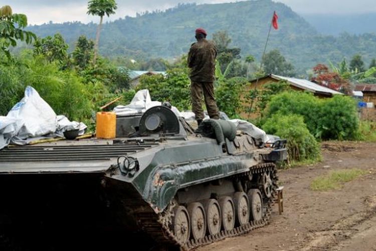 Seorang prajurit AD Republik Demokratik Kongo menatap puncak bukit Mbuzi sambil berdiri di atas sebuah tank di Rushturu, Selasa (4/11/2013), setelah berhasil merebut wilayah itu dari pemberontak M23. Setelah terus dipukul mundur dari sejumlah posisi penting, pemberontak M23 akhirnya bersedia meletakkan senjata.