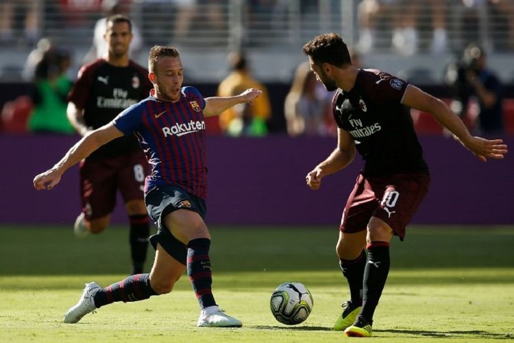 Arthur Melo mencoba melewati penjagaan Hakan Calhanoglu saat Barcelona berhadapan dengan AC Milan di Santa Clara, 4 Agustus 2018. 