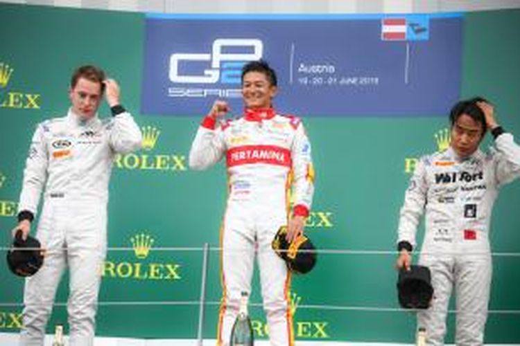 Pebalap Campos Racing asal Indonesia, Rio Haryanto (tengah), berdiri di atas podium setelah memenangi sprint race GP2 Austria di Sirkuit Red Bull, Spielberg, Minggu (21/6/2015). Stoffel Vandoorne (kiri) finis kedua dan Nobuharu Matsushita finis ketiga.