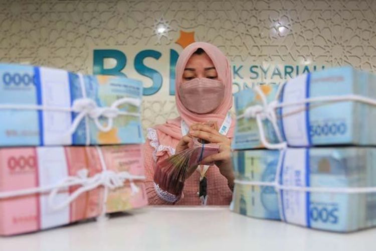Karyawan Bank Syariah Indonesia sedang menghitung uang.