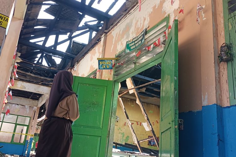 Seorang siswi SMPN 20 Kota Jambi tengah berdiri melihat kondisi ruang kelasnya yang terbakar pada Rabu (10/9/2025) pukul 6.15 WIB.
