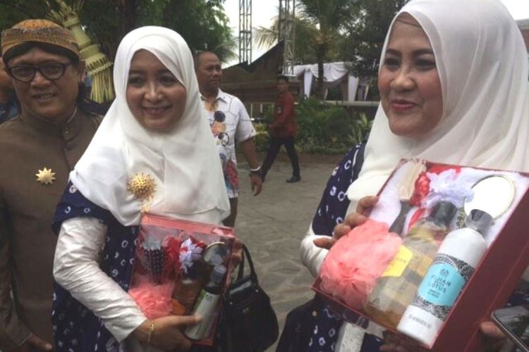 Haryani (kanan), menunjukkan souvenir dari acara siraman Kahiyang Ayu di Solo, Jawa Tengah (7/11/2017).