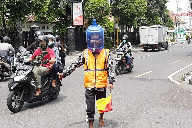 Ali Akbar mengenakan galon bekas saat mengatur lalu lintas di pertigaan Jalan Taman Siswa, Kota Yogyakarta