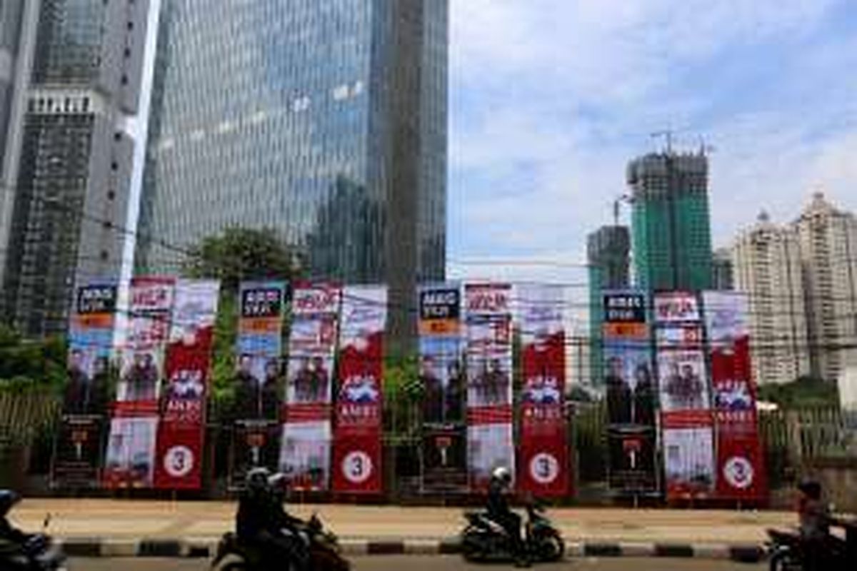 Pengendara sepeda motor melaju di samping baliho bergambar tiga pasangan calon Gubernur dan Wakil Gubernur DKI Jakarta di Jalan Kuningan, Jakarta, Rabu (23/11/2016). KPU DKI Jakarta menyediakan alat peraga kampanye untuk setiap pasangan calon dengan jumlah yang sama, namun apabila masih dirasa kurang mencukupi, masing-masing pasangan calon dibebaskan menambah alat peraga maksimal sebanyak 150 persen dari yang diadakan KPU.