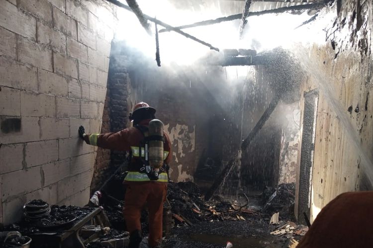 Petugas saat memadamkan api yang membakar enam rumah di Surabaya