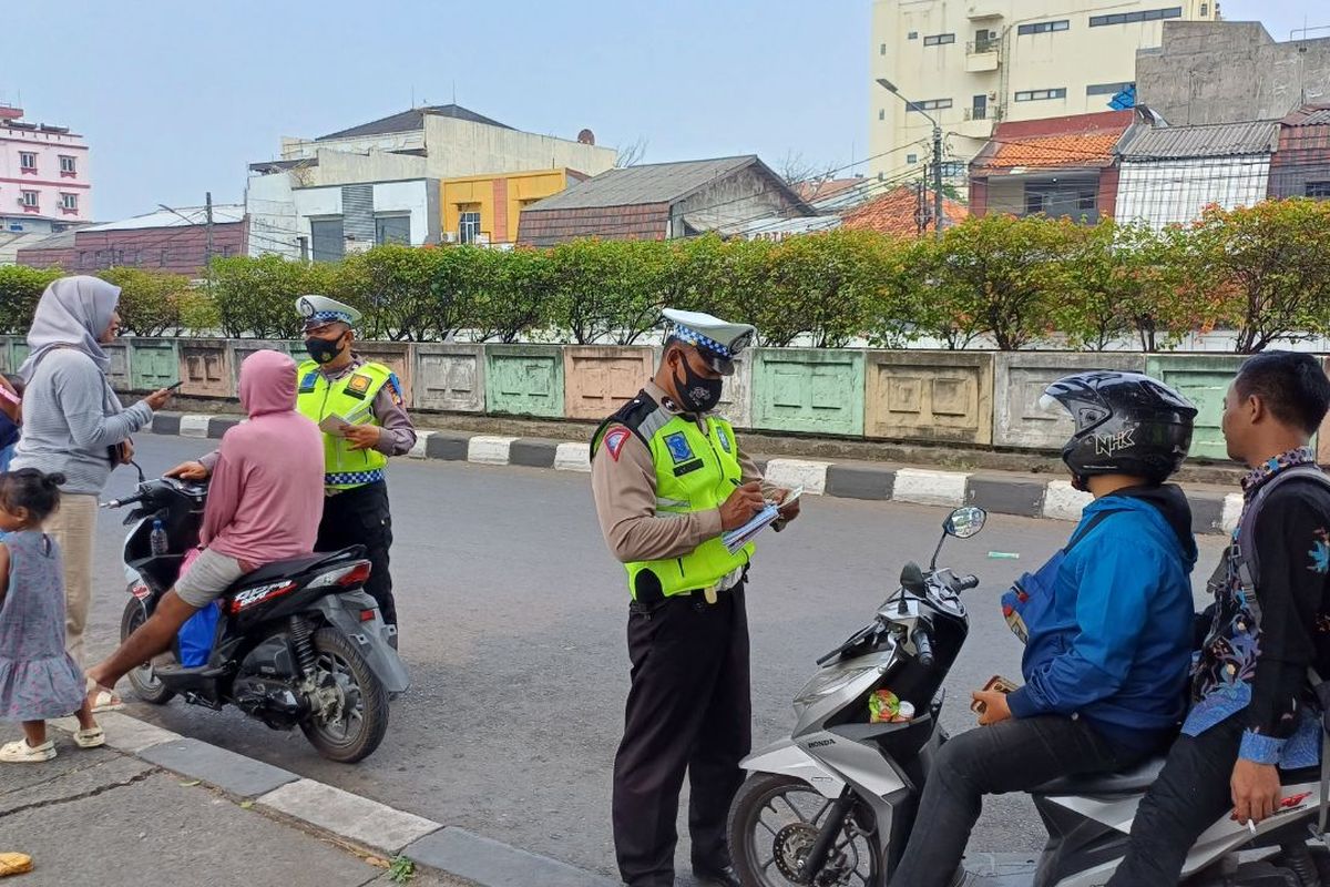Sejumlah pemotor ditilang karena tak mengenakan helm saat melintas di depan Stasiun Pasar Minggu, Jakarta Selatan, Kamis (21/9/2023).