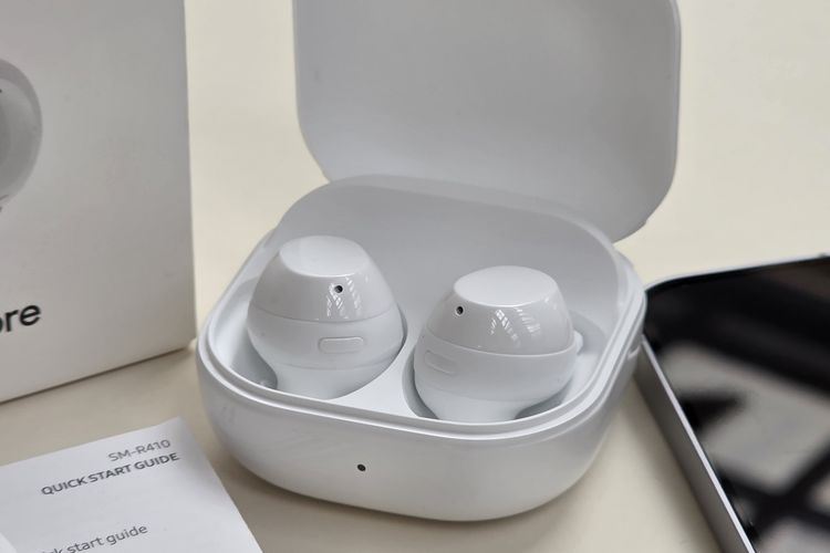 Cangkang atau charging case TWS Galaxy Buds Core ini mengusung desain kotak, dan di dalamnya terdapat wadah untuk mengisi daya dua earbud, masing-masing untuk telinga kiri dan kanan.
