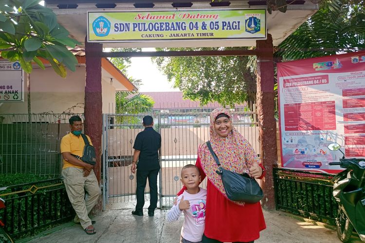 Sami'na (37) mengantar anaknya, Mufidah (6), bersekolah di SD Negeri Pulo Gebang 04, Cakung, Jakarta Timur, Rabu (12/7/2023).