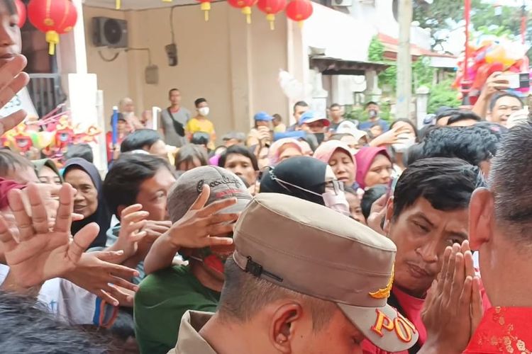 Warga yang berebut angpao ketika perayaan Hari Raya Imlek 2574/2023 di Keleteng Hok Lay Kiong, Kota Bekasi, Minggu (22/1/2023). Ratusan warga itu diketahui sudah menunggu di depan kelenteng sejak pagi sekitar pukul 07.00 WIB.