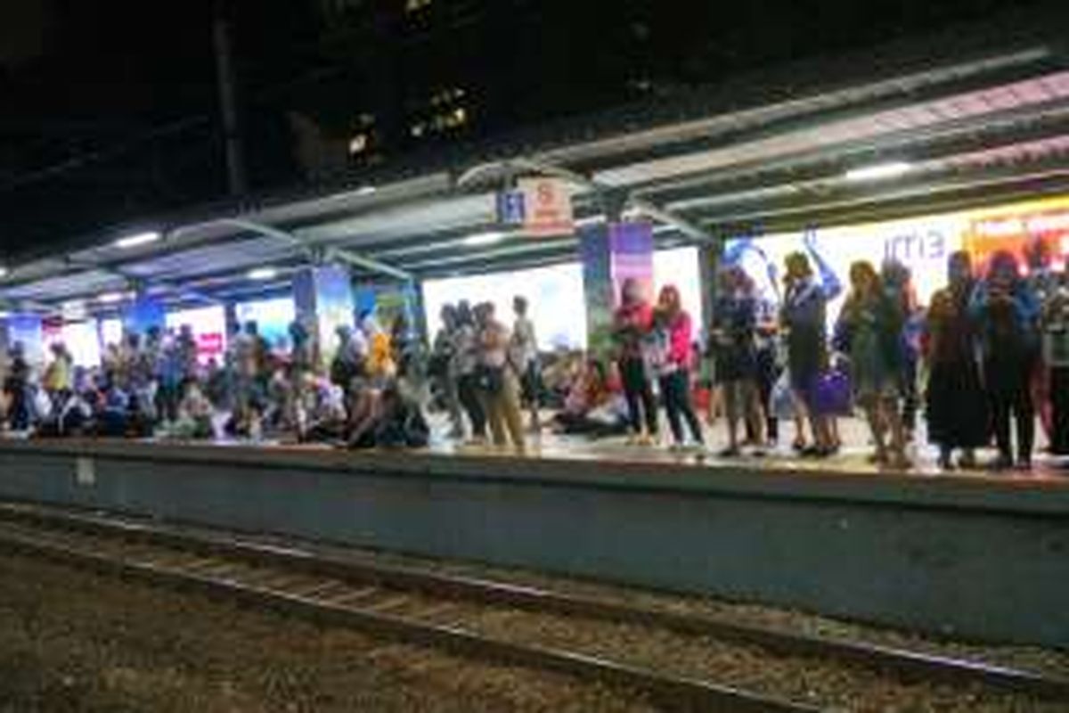 Penumpang menumpuk di peron 2 Stasiun Sudirman akibat lamanya KRL tujuan Bogor yang tiba. Sebagian dari mereka terpaksa duduk di pinggir peron, Rabu (6/4/2016).