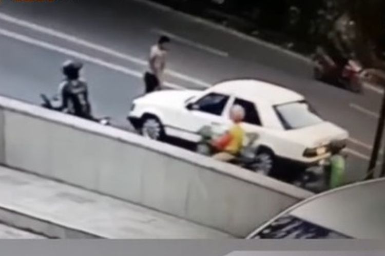 Tangkapan layar video viral memperlihatkan seorang sekuriti sebelum ditabrak sedan berwarna putih usai memberi akses jalan mobil lain di Jalan Pattimura, Medan.