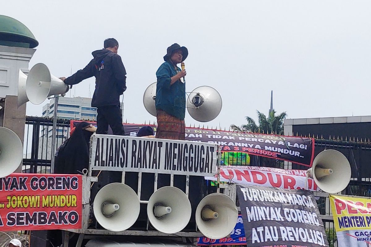 Sunarti (berbaju hijau, memegang mik), massa aksi yang mengenakan baju adat, saat berunjuk rasa di depan Gedung DPR/MPR, Jakarta, Kamis (21/4/2022).