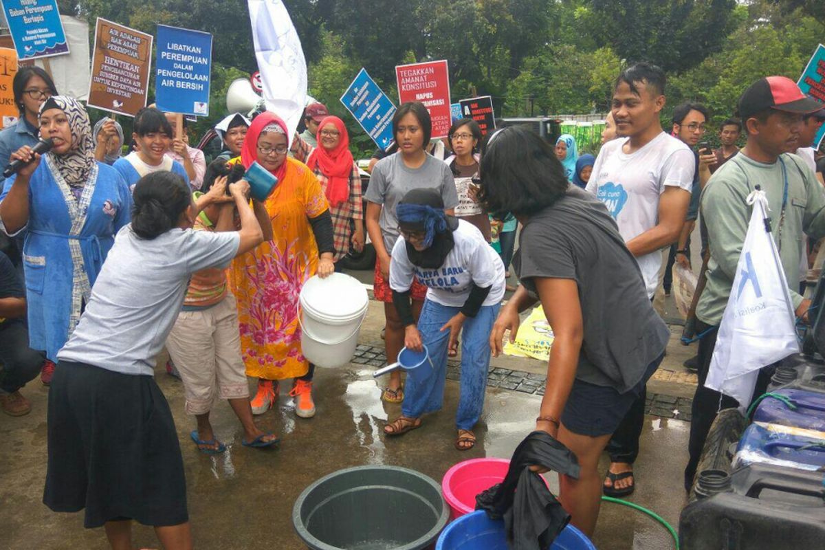 Massa menuntut air murah dengan melakukan aksi mandi bersama di depan kantor Balai Kota DKI Jakarta, Rabu (22/3/2018).
