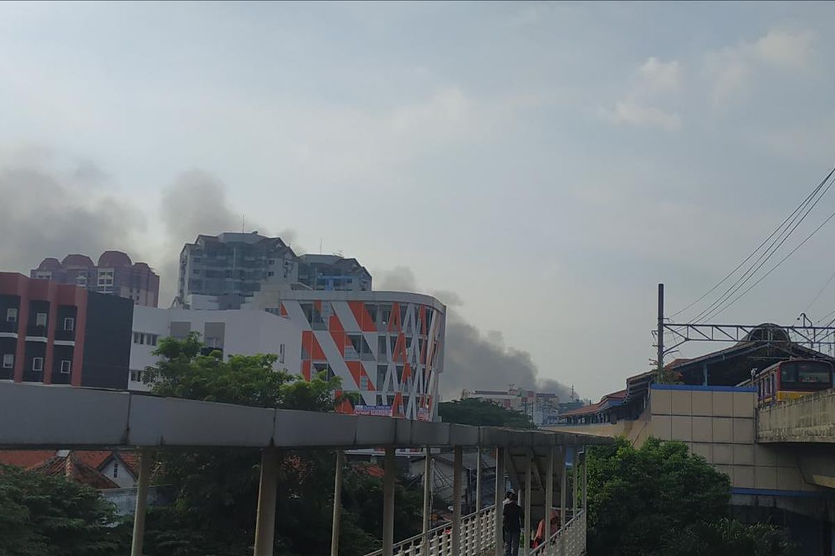 Asap kebakaran yang melalap pemukiman warga di Kampung Bandan, Jakarta Utara membubung tinggi, terlihat dari jembatan penyeberangan orang Juanda, Sabtu (11/5/2019) petang.